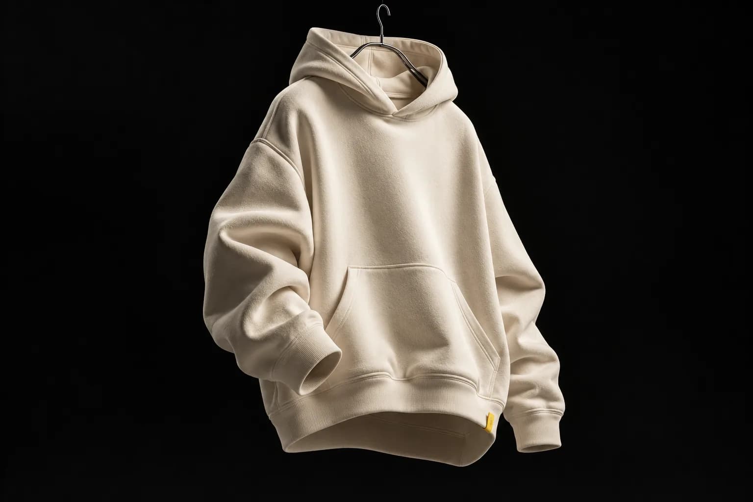 A cream heavyweight hoodie floating against a black background